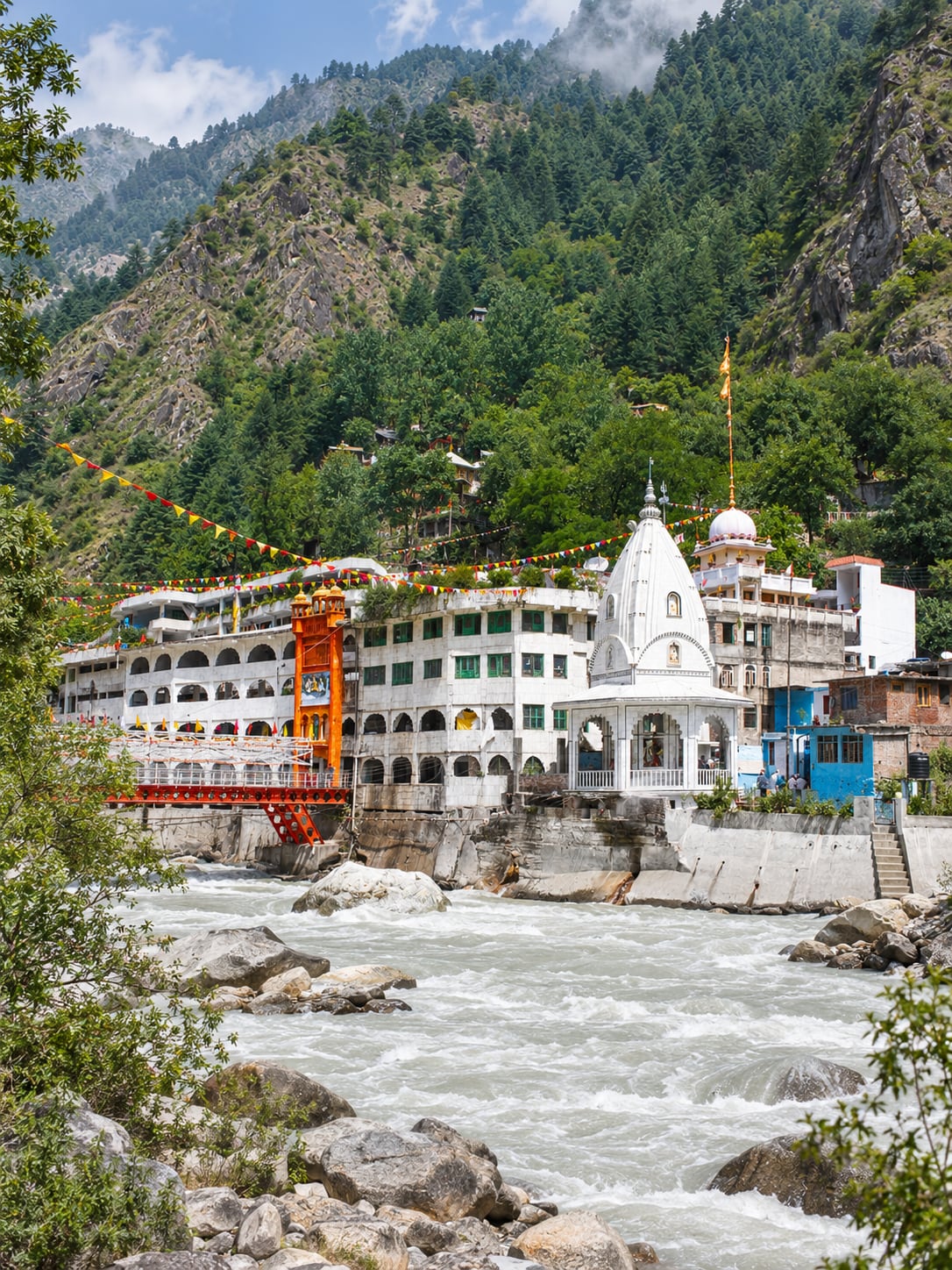 Illustration of Manikaran's riverside religious buildings beneath the steep wooded slope